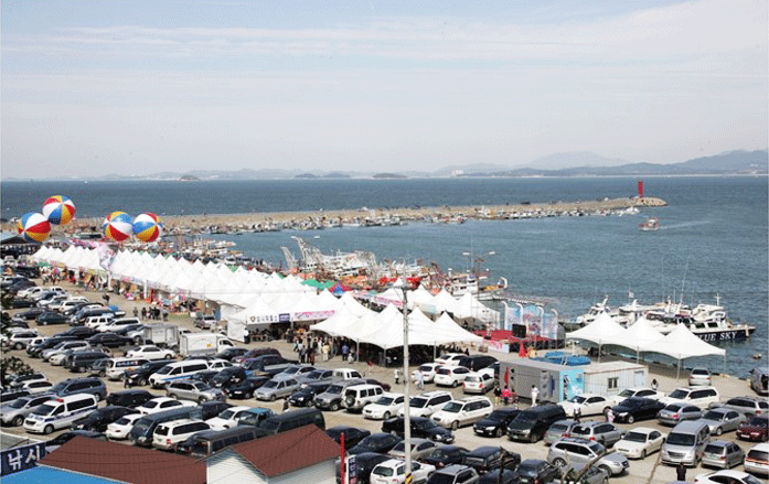 홍원항 마리나 및 숙박시설 주변의 전어&middot;꽃게축제를 하고 있는 사진입니다.